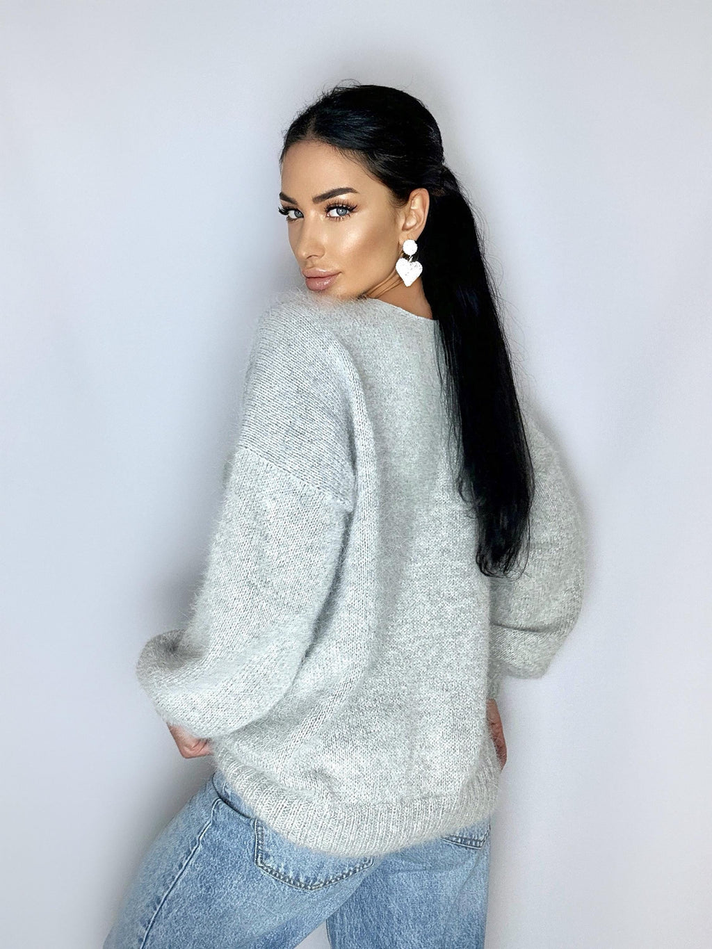 May include: A gray fuzzy sweater with long sleeves and a v-neck. The sweater is made of a soft, comfortable material.