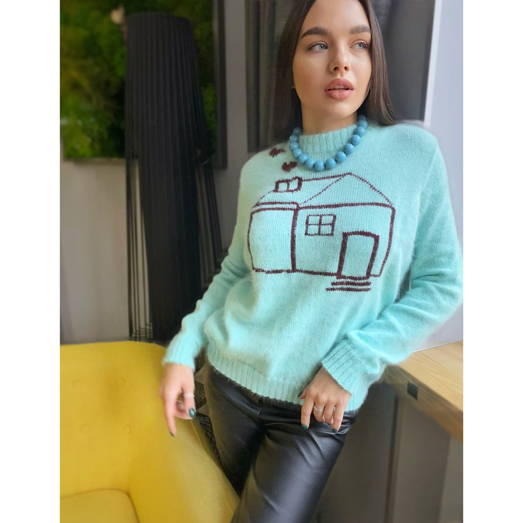 May include: A light blue fuzzy sweater with a brown cartoon house design. The sweater has a round neck and long sleeves.