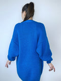 May include: A bright blue knitted cardigan with long sleeves and a relaxed fit.